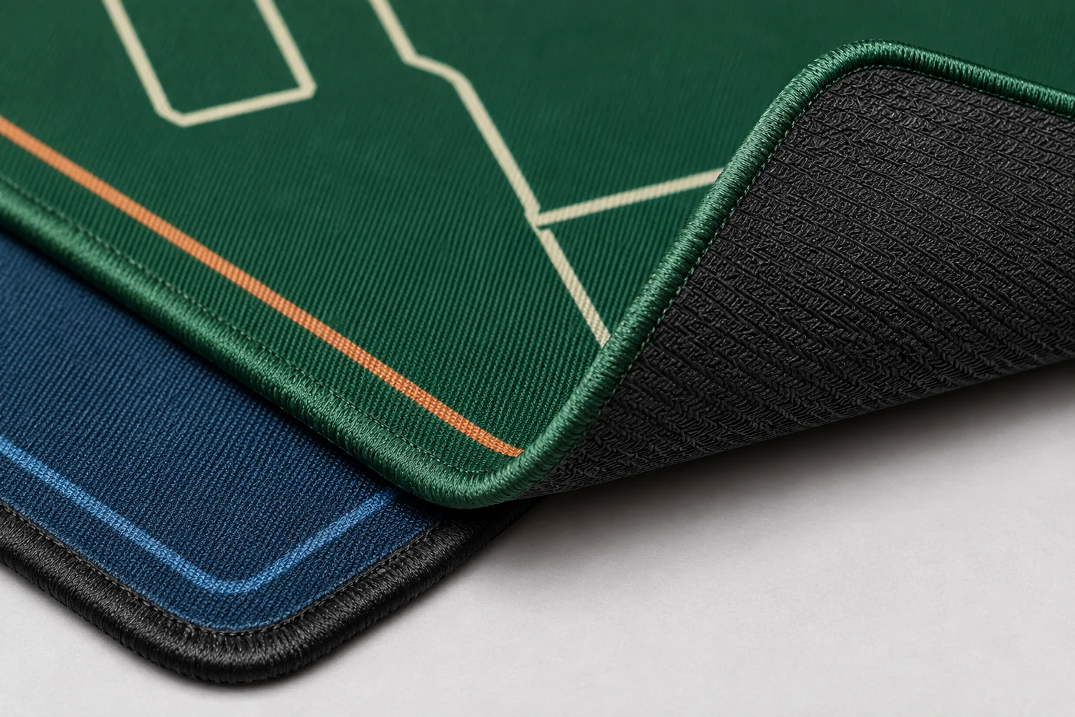 Printed fabric surface, finished edge and rubber backing detail on a custom game mat